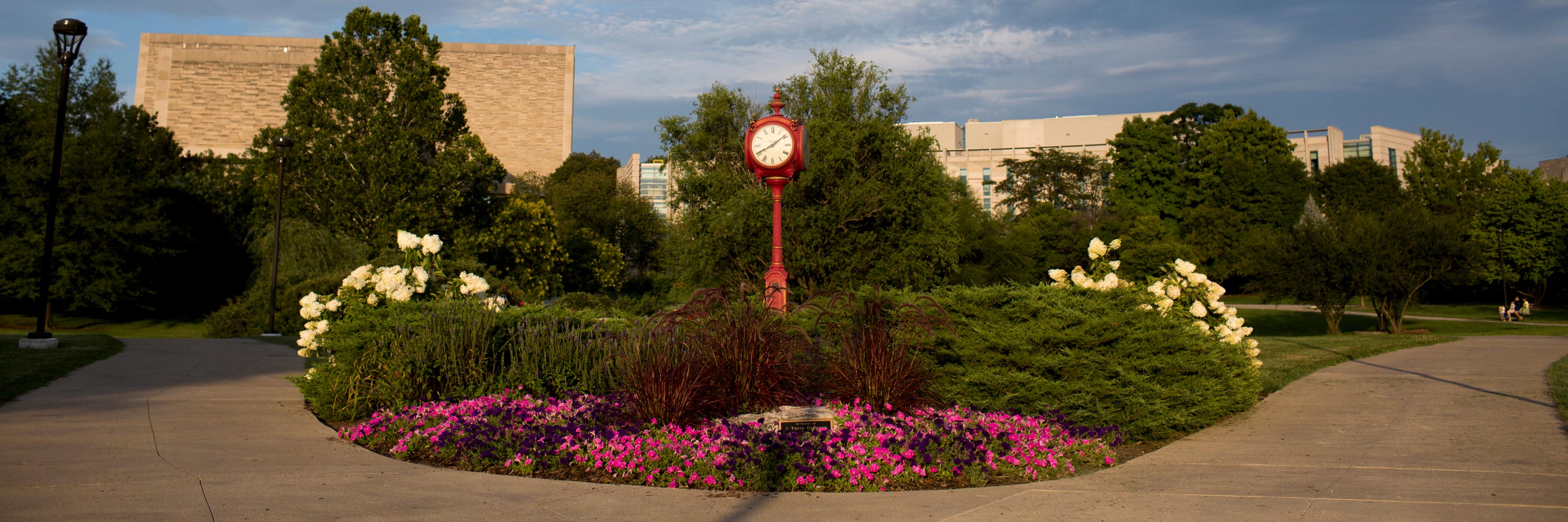 flowers, pathway, and decorative red clock